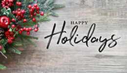 ANV happy-holidays-text-christmas-evergreen-ANV branches-red-winter-holiday-berries-corner-over-rustic-wooden-background-203494899